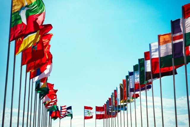 青空の下で並ぶ各国の国旗。