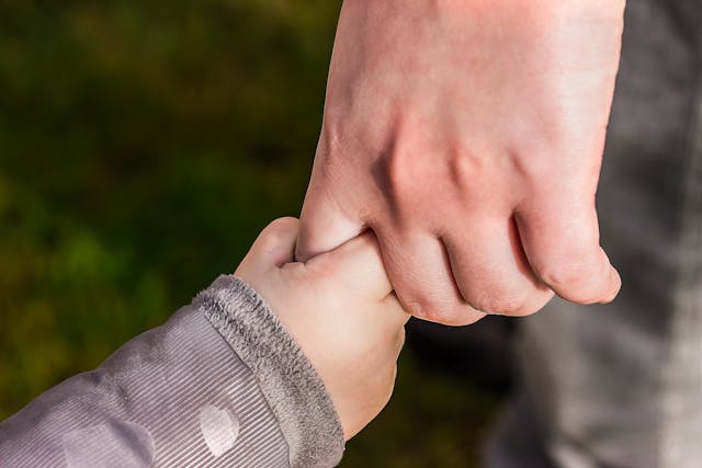 手をつないだ親と子供