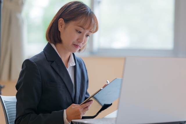 条件を確認している女性社員