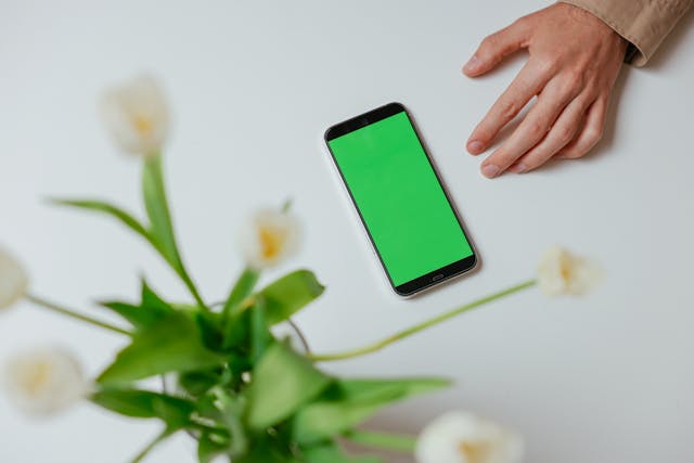 e-ラーニングを受講するためのスマホを手に取る場面