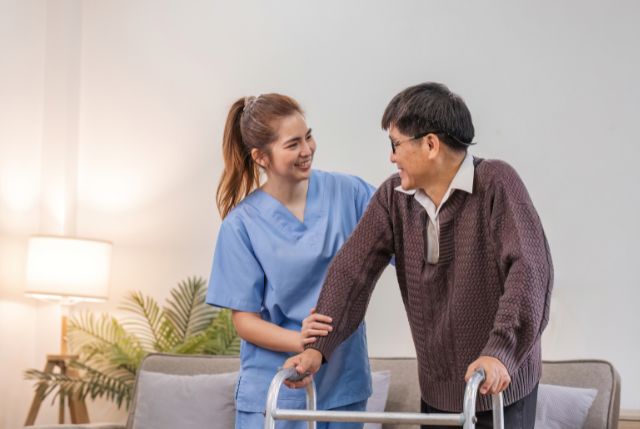 高齢男性を補助している外国人介護士