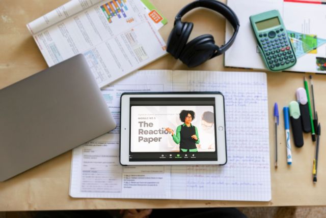 机の上に置かれたタブレットやパソコン、ヘッドフォンなどのオンラインでの日本語学習に必要なツール