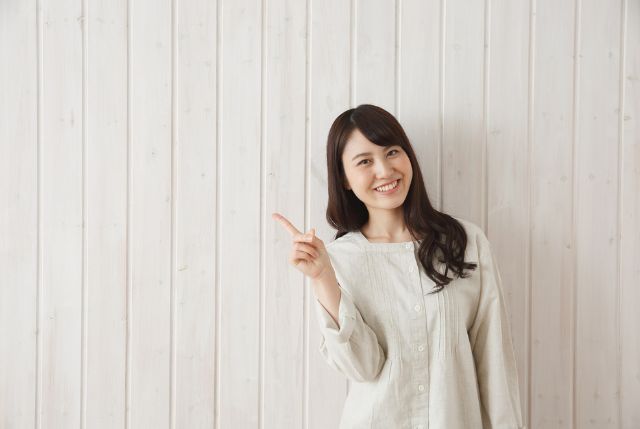 人差し指を立ててポイントを説明している笑顔の女性
