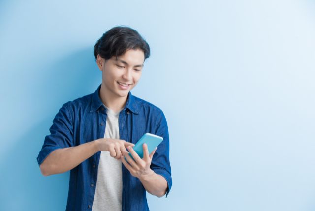 スマホで日本語学習をしている外国人男性