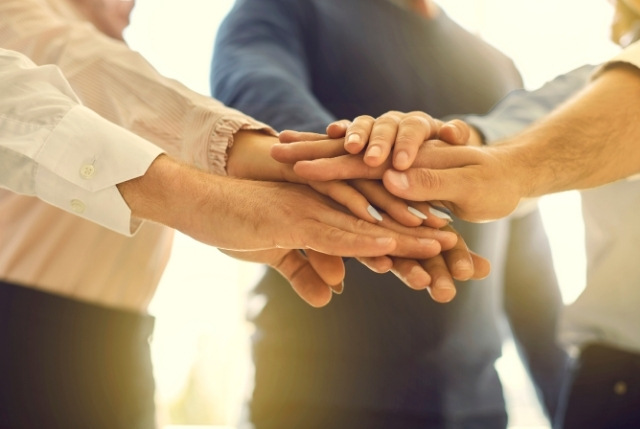 学習サポートをしている受け入れ企業の社員が円陣を組んで応援している場面