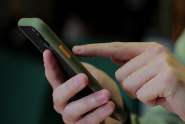 日本語学習アプリを操作するスマートフォンの手元