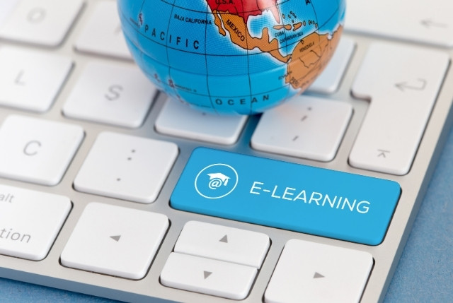 キーボードに書かれたE-LEARNINGの文字とその上に置かれた小さな地球儀