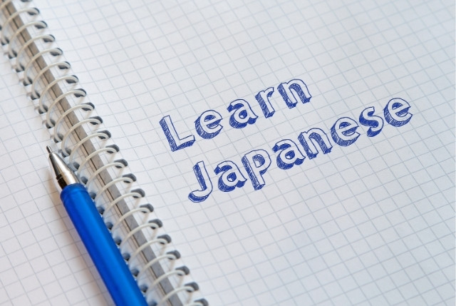 ノートに青いペンで書かれたLearn Japaneseの文字