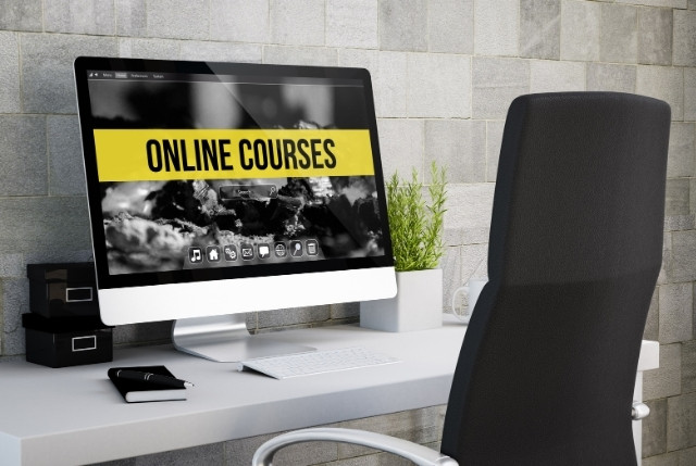 デスク上のパソコン画面に「ONLINE COURSES」と表示された様子。特定技能のオンライン講座を活用した企業の教育コスト削減や人材育成を示すイメージ。
