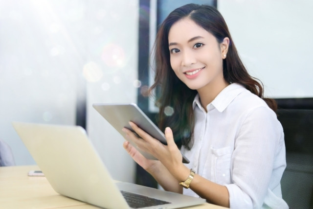 パソコンとタブレットを使ってオンライン学習を受講している外国人女性