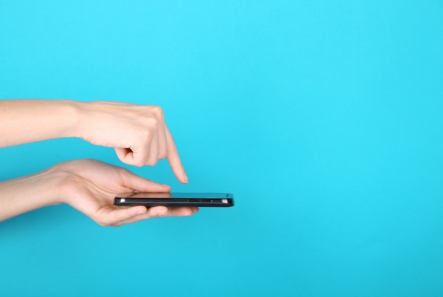 スマホのスクリーンをタッチしようとしている手