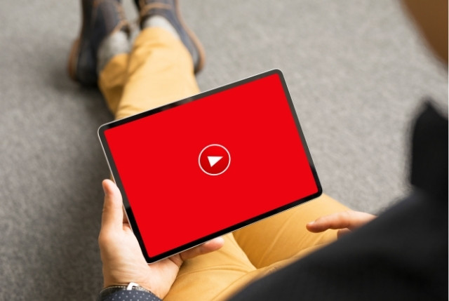 タブレットで特定技能学習の動画を再生しようとする外国人男性の手元