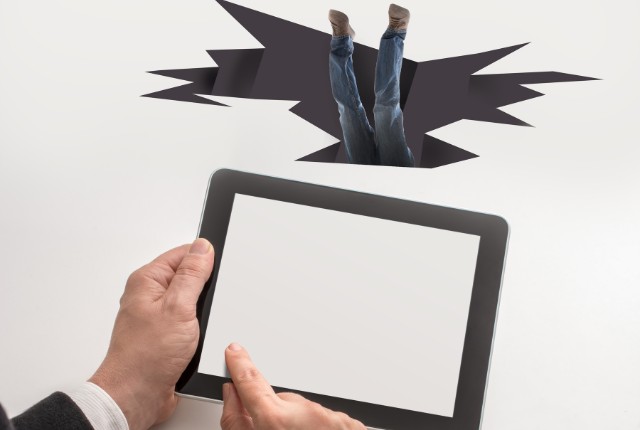 タブレット画面から人の足が飛び出し、仮想空間に落ちるように見えるユニークな合成画像。企業が日本語教育で陥る罠を象徴。