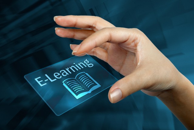 指先でホログラムの「E-Learning」アイコンを操作するイメージ。オンライン教育やデジタル学習の選び方を象徴するビジュアル。