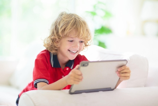タブレットで日本語学習アプリを楽しむ子供。オンライン教材を使った子供向け日本語教育のイメージ。