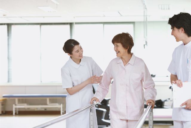 リハビリ施設で看護助手が高齢者をサポートする様子。外国人介護人材の仕事内容の例。