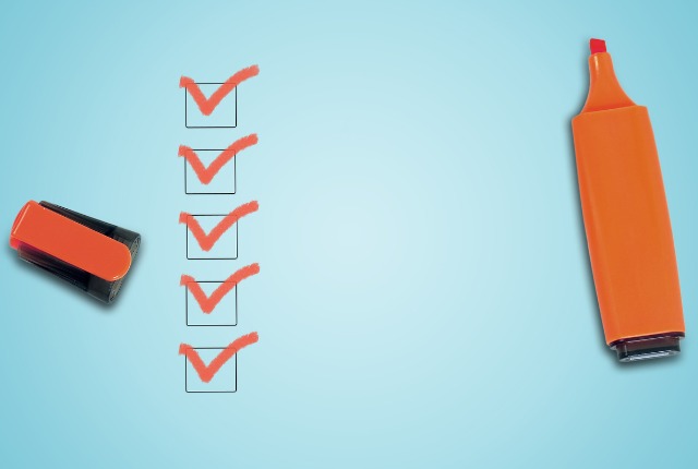 赤いチェックマークが並ぶチェックリストとマーカー。特定技能2号への移行に関する試験対策やオンライン学習準備の進捗管理をイメージ。