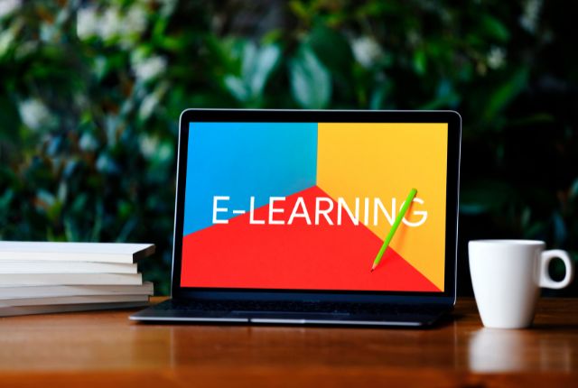 ノートPCに「E-LEARNING」と表示された教材画面。オンライン学習や企業向け日本語研修の説明用イメージ。