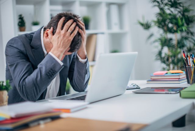 外国人への日本語教育で頭を抱えるビジネスパーソンの写真。外国人社員向け日本語研修の記事用イメージ。