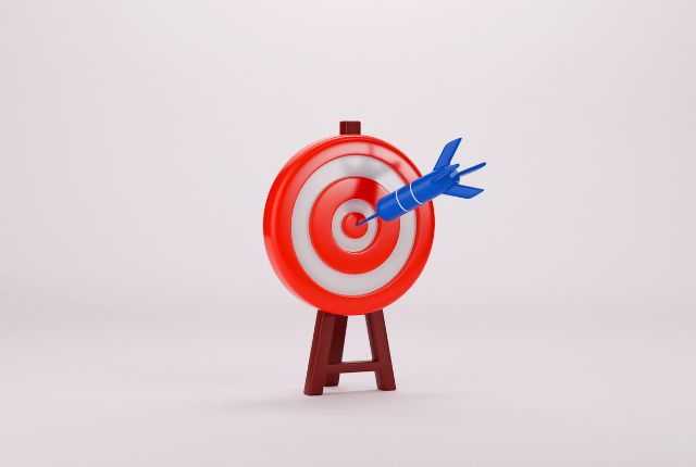 赤と白の的に青いダーツが命中しているイラスト。学習目標や達成を象徴するビジュアルイメージ。