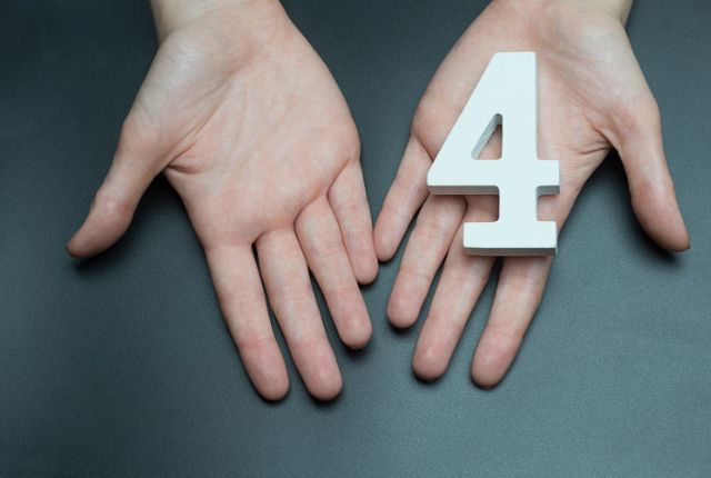 介護業界の外国人採用における4つの制度を示す、数字の4を手に持つイメージ