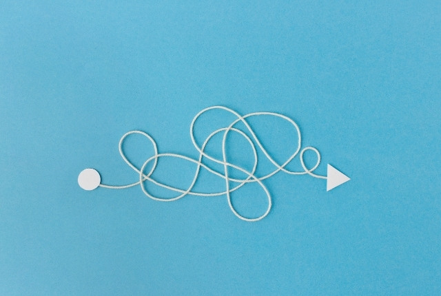 外国人スタッフ受け入れ時の課題と解決までのプロセスを示す、複雑な道筋と矢印のイメージ