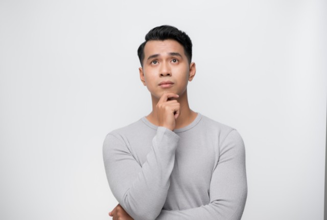 日本語教育でつまずく外国人男性考える男性のイメージ写真。JLPT学習やeラーニング活用を連想させる構図。