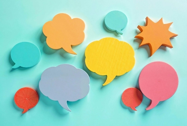 外国人介護士との会話のすれ違い 水色の背景にカラフルな吹き出し形の紙が並んでいるイメージ