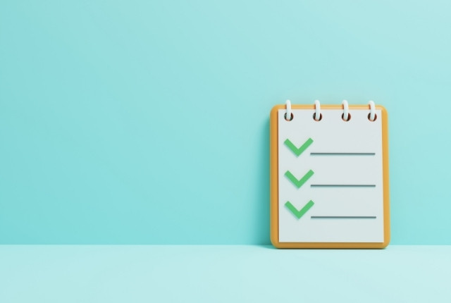 伝わる指示のポイント 水色の背景にチェックマーク付きのメモ帳が置かれているイメージ